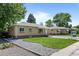 Charming brick home featuring a well-maintained lawn, gravel landscaping, and mature trees in a quiet neighborhood at 2582 S Uno Way, Denver, CO 80219