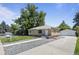 Charming single-story home features a well-manicured lawn, a detached garage, and a brick exterior at 2582 S Uno Way, Denver, CO 80219