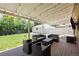 Inviting covered patio area with stylish outdoor furniture, string lights, and spacious backyard at 2582 S Uno Way, Denver, CO 80219
