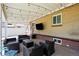 Relaxing covered patio featuring stylish seating, an outdoor television, and attractive brick accents at 2582 S Uno Way, Denver, CO 80219