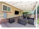 Charming covered patio area with outdoor seating, string lights, and a flat screen television at 2582 S Uno Way, Denver, CO 80219
