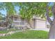 Charming two-story home with a stone facade, inviting front porch, and well-manicured lawn at 12021 Dahlia Dr, Thornton, CO 80241