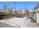 Backyard with partially snow-covered patio area features a trailer, and a wood privacy fence at 1535 Spruce St, Denver, CO 80220