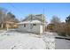 Backyard view features the rear of the two-story home with snow, and a deck area at 1535 Spruce St, Denver, CO 80220