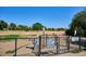 View of the gated off-leash dog park with waste bag stations and multiple rules and information signs at 1535 Spruce St, Denver, CO 80220