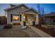 Exterior view of the home at dusk features a rocking chair front porch and gravel landscaping at 1535 Spruce St, Denver, CO 80220