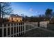 Dusk exterior view of the home features a white picket fence and gravel landscaping at 1535 Spruce St, Denver, CO 80220