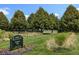 Greenway Park sign surrounded by well-maintained grass, mature trees, and a tennis court in the background at 1535 Spruce St, Denver, CO 80220