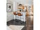 Open kitchen with breakfast bar, stylish stools, and decorative brick wall at 1535 Spruce St, Denver, CO 80220
