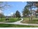 Picturesque view of William Mcnichols Park on a beautiful day with walking paths and mature trees at 1535 Spruce St, Denver, CO 80220