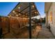 Dusk view of an enclosed patio area with seating, lighting, and a unique swinging chair at 1535 Spruce St, Denver, CO 80220