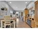 Cozy dining area with a wooden table and bench, seamlessly connected to the kitchen and living spaces at 8885 W 64Th Pl, Arvada, CO 80004