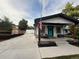 Charming bungalow-style home featuring white siding, black trim, and a cozy front porch with a blue door at 8885 W 64Th Pl, Arvada, CO 80004
