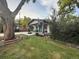 Charming bungalow-style home featuring white siding, black trim, and a cozy front porch with a blue door and large trees at 8885 W 64Th Pl, Arvada, CO 80004
