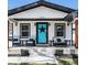 Charming home featuring a stylish front porch with cozy seating and a vibrant blue door at 8885 W 64Th Pl, Arvada, CO 80004