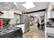 Galley kitchen with stainless steel fridge, black stove, white cabinets and view to the living room at 8885 W 64Th Pl, Arvada, CO 80004