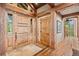Grand entryway with exposed beams, hardwood floors, and custom doors creates a welcoming first impression at 2929 Highlands View Rd, Evergreen, CO 80439