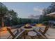 Inviting backyard fire pit with chairs and table, surrounded by greenery at 2929 Highlands View Rd, Evergreen, CO 80439