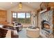 Comfortable living room featuring a stone fireplace, large windows with scenic views, and plush seating at 2929 Highlands View Rd, Evergreen, CO 80439