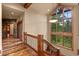 Bright staircase with wood railing, hardwood floor, and large windows with a view at 2929 Highlands View Rd, Evergreen, CO 80439
