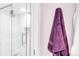 Modern bathroom with a glass shower door, subway tile surround, and plum colored towels at 5955 E 10Th Ave # 507, Denver, CO 80220