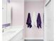 Clean bathroom featuring a white vanity, lilac walls, chrome fixtures, and decorative towels at 5955 E 10Th Ave # 507, Denver, CO 80220