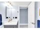 Bright, airy bathroom featuring a modern vanity, mirror, and open doorway at 5955 E 10Th Ave # 507, Denver, CO 80220