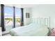 Bright bedroom with light green walls, large windows, and view of neighborhood at 5955 E 10Th Ave # 507, Denver, CO 80220