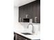 Close up of the kitchen sink with modern faucet and dark cabinets with stainless steel handles at 5955 E 10Th Ave # 507, Denver, CO 80220