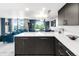 A bright kitchen featuring dark cabinets and a view into a spacious living and dining area at 5955 E 10Th Ave # 507, Denver, CO 80220
