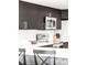 Modern kitchen featuring dark cabinets, stainless steel appliances, and a sleek white countertop at 5955 E 10Th Ave # 507, Denver, CO 80220