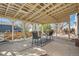 Covered backyard patio with an outdoor dining set on a patterned rug and a concrete floor at 4272 E 126Th Pl, Thornton, CO 80241