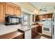 Functional kitchen with ample counter space, bright white appliances, and a convenient microwave shelf at 4272 E 126Th Pl, Thornton, CO 80241