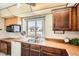 Bright kitchen with wood cabinets, a stainless steel sink, and large window overlooking the front yard at 4272 E 126Th Pl, Thornton, CO 80241