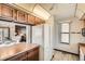 Cozy kitchen featuring wood cabinets, white appliances and wood-look flooring with easy access to the living room at 4272 E 126Th Pl, Thornton, CO 80241