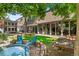 Lush backyard oasis features a stock tank hot tub, mature trees, and a manicured lawn at 50 Albion St, Denver, CO 80220