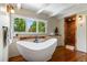 Bright bathroom features a soaking tub under a window and a walk-in shower at 50 Albion St, Denver, CO 80220