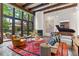 Bright living room featuring a fireplace, piano, large windows, and comfortable seating area at 50 Albion St, Denver, CO 80220