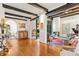 Bright living room featuring hardwood floors, exposed beams, a fireplace, piano, and large windows at 50 Albion St, Denver, CO 80220