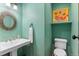 Stylish powder room with a pedestal sink, unique mirror, and vibrant paint color at 50 Albion St, Denver, CO 80220