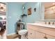 Cozy bathroom with light blue walls, a mirrored cabinet, and a shower with glass doors at 2012 W 101St Ave, Thornton, CO 80260