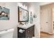 Updated bathroom featuring a modern vanity with a sink, mirror, and decorative towel racks at 2012 W 101St Ave, Thornton, CO 80260