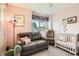 Charming Bedroom with a cozy gray couch, a crib, and a window letting in natural light at 2012 W 101St Ave, Thornton, CO 80260