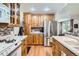 Bright kitchen featuring wood cabinets, stainless steel refrigerator, and mosaic backsplash at 2012 W 101St Ave, Thornton, CO 80260