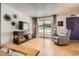 Bright living room featuring wood floors, media center, comfortable seating, and sliding door to the backyard at 2012 W 101St Ave, Thornton, CO 80260
