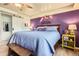 Spacious main bedroom featuring a king bed, ceiling fan, and a striking purple accent wall at 2012 W 101St Ave, Thornton, CO 80260
