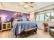 Main bedroom boasts a ceiling fan, a purple accent wall, and a window with natural light at 2012 W 101St Ave, Thornton, CO 80260