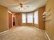 Spacious bedroom with large bay window, ceiling fan, closet, and neutral carpet at 8461 Pawnee Ln, Niwot, CO 80503