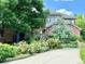 Two-story brick home with mature landscaping, flower beds, and a concrete driveway at 8461 Pawnee Ln, Niwot, CO 80503