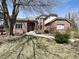 Charming red brick home with mature tree in the front yard on a sunny day at 8461 Pawnee Ln, Niwot, CO 80503
